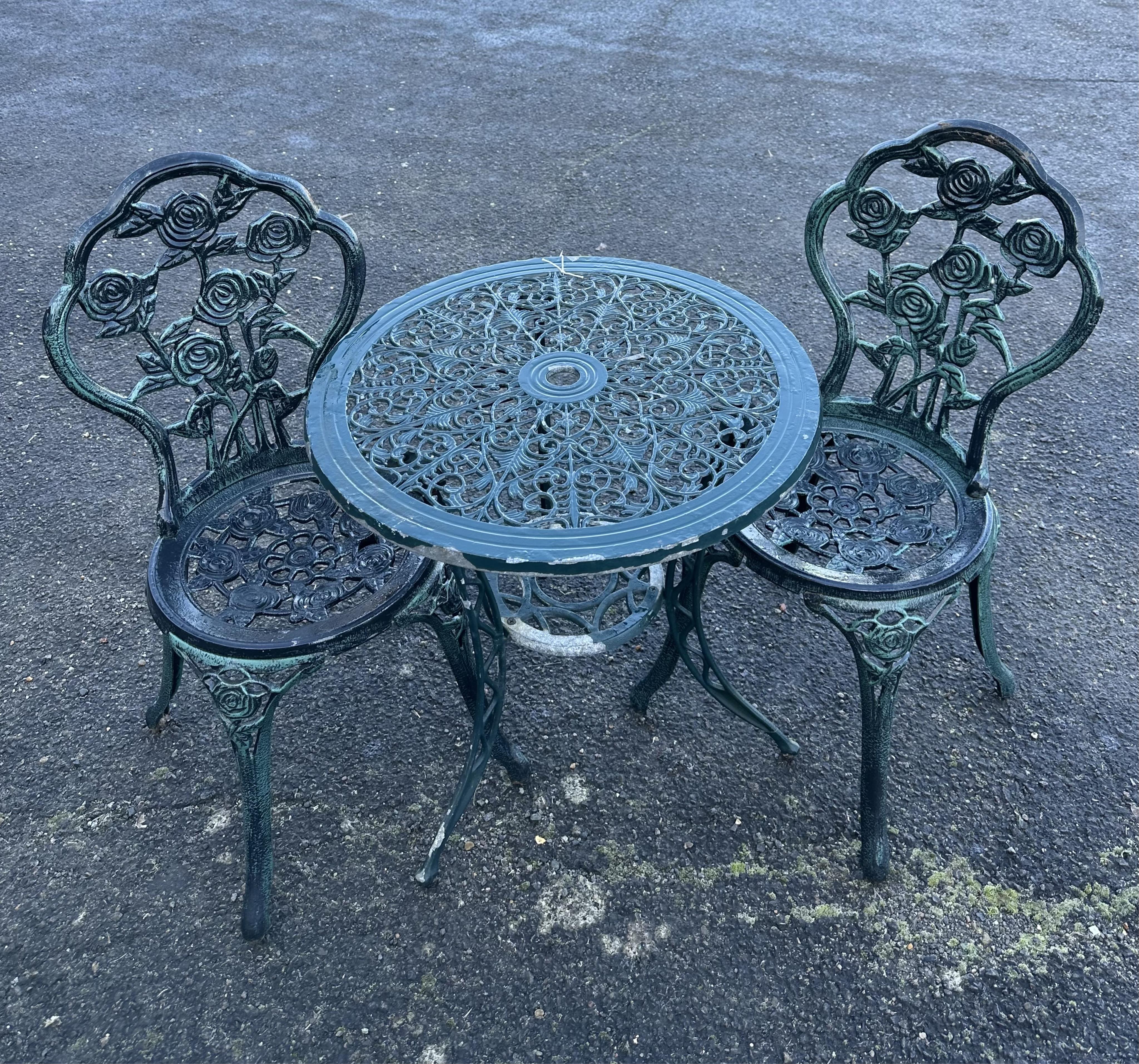 An aluminium garden table, diameter 60cm and a pair of chairs. Condition - poor